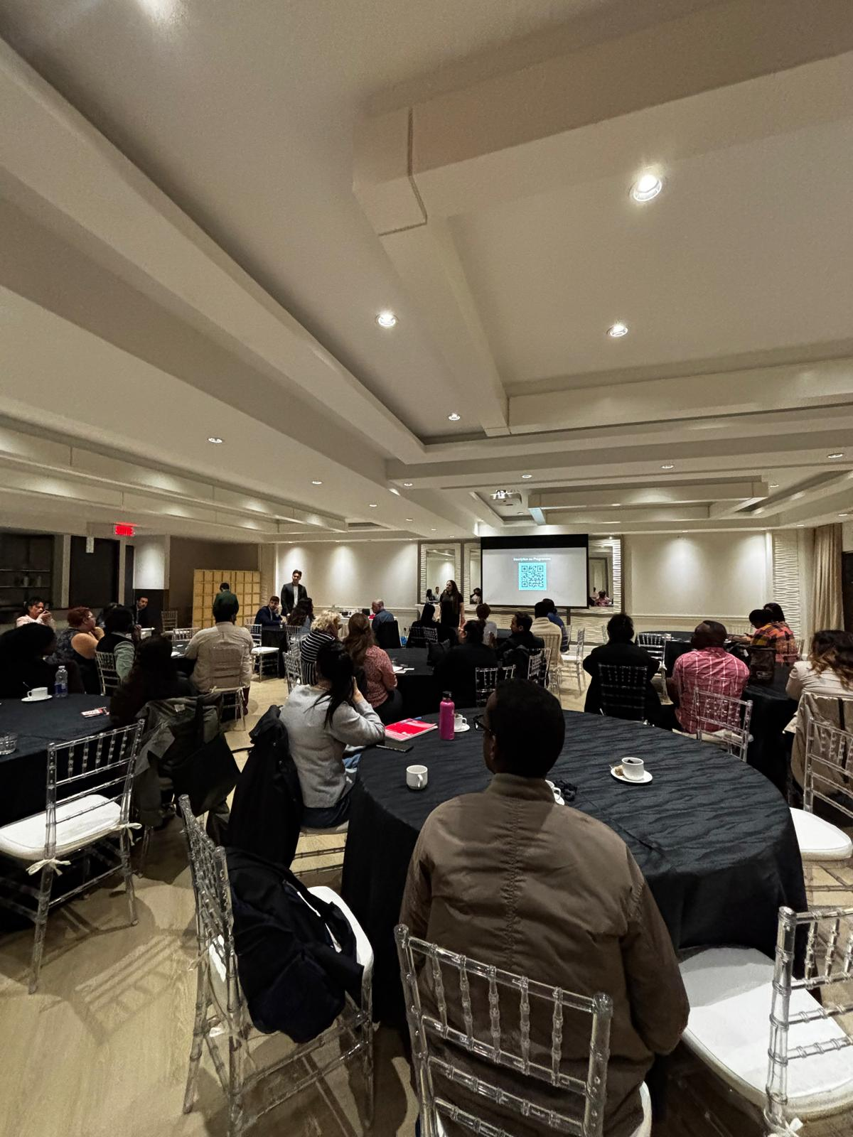 Événement Madame Condo dans une salle lumineuse : participants assis face à un écran de projection.
